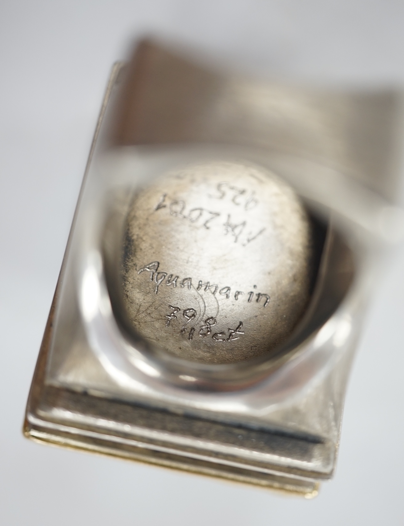 An Elizabeth II silver christening mug, three silver mounted dressing table items, a silver mounted desk calendar, a silver capstan inkwell and a sterling condiment. Condition - fair to good